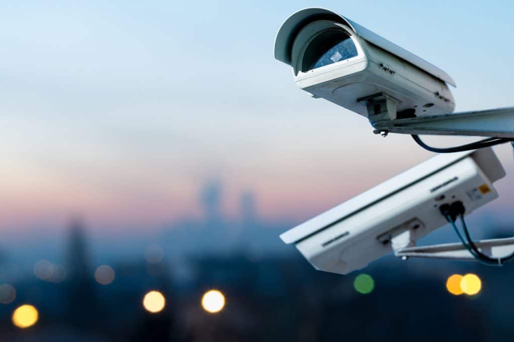 security CCTV camera monitoring system with panoramic view of a city on blurry background